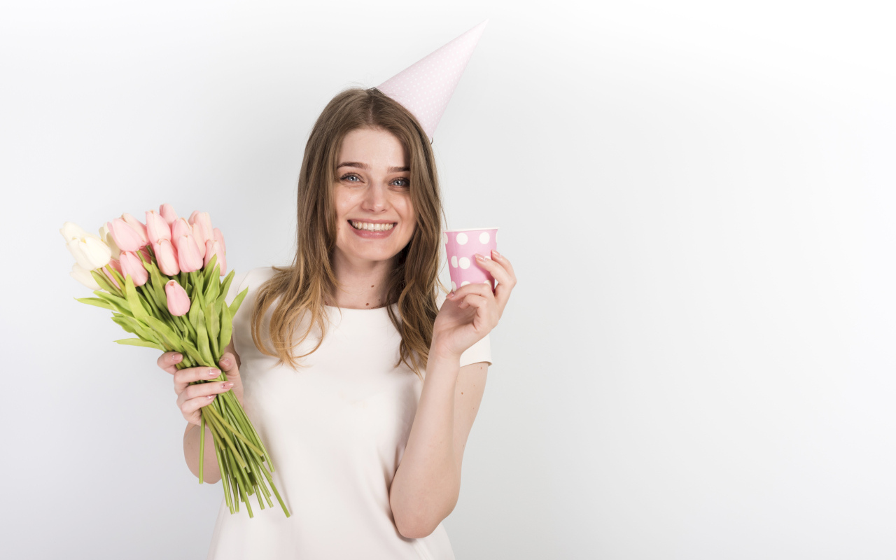 Счастливая девушка с букетом тюльпанов и подарком на день рождения
