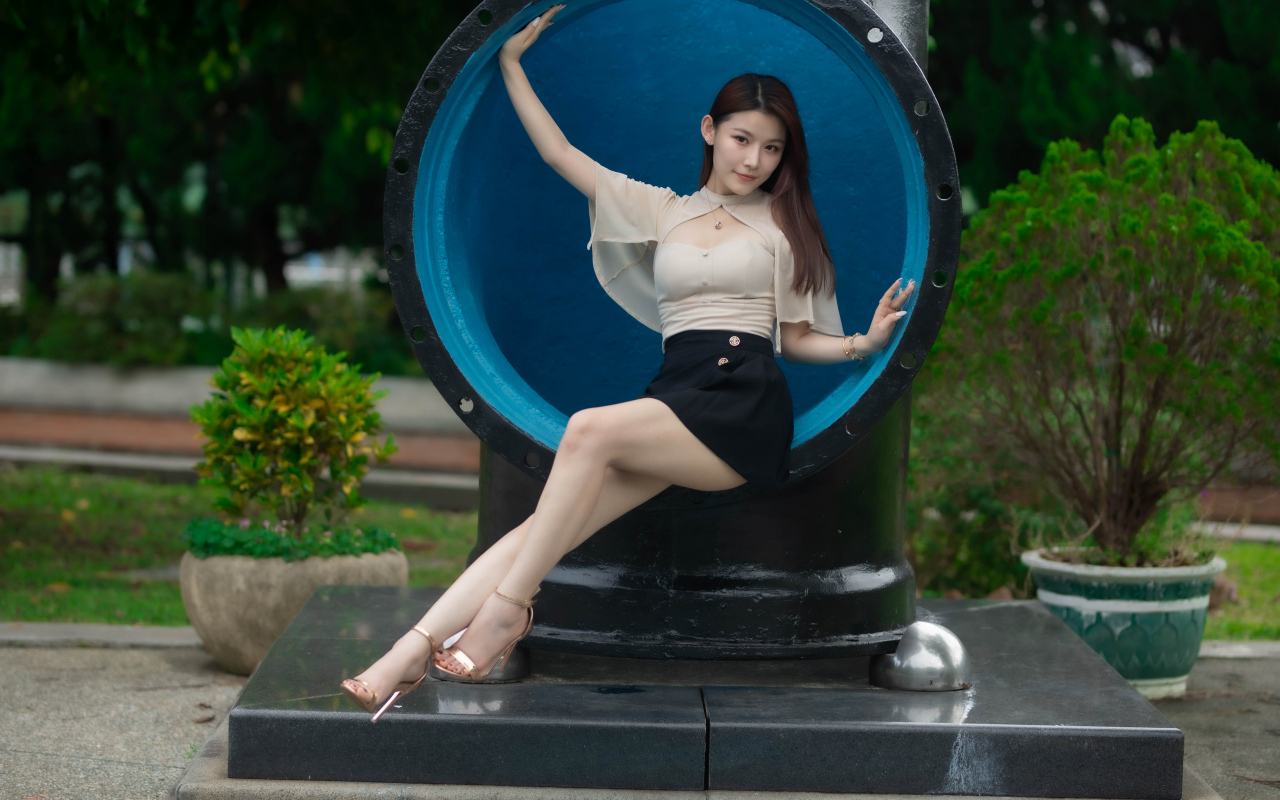 Стройная длинноногая азиатка сидит в трубе