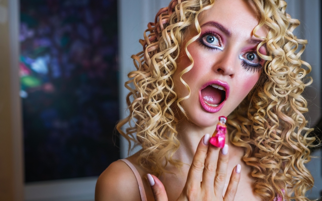 Удивленная девушка блондинка с макияжем куклы