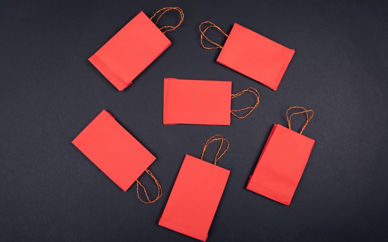 Красные пакетики для подарков на черном столе