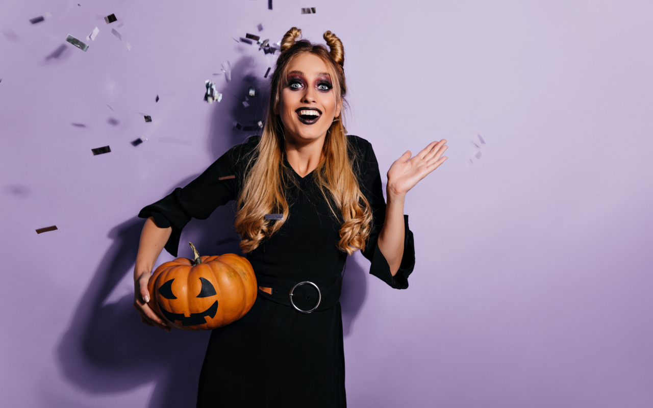 Девушка в черном костюме с тыквой на праздник Хэллоуин