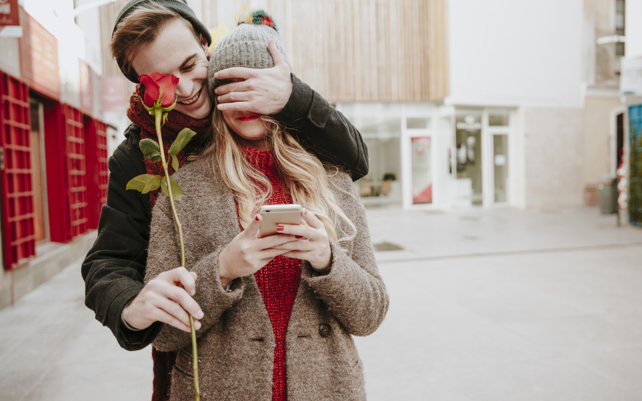 Влюбленный парень дарит девушке красную розу
