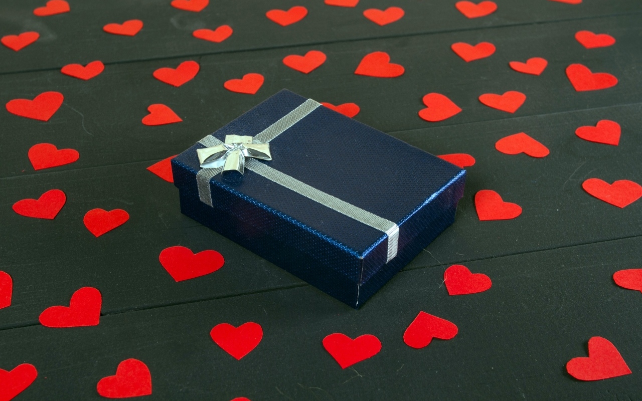Черная коробка с красными сердечками на столе