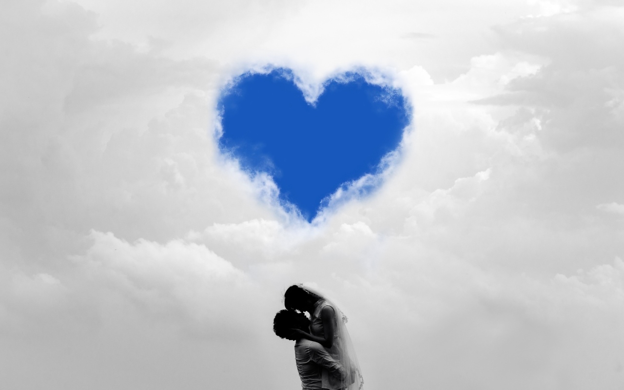 Пара на фоне сердца в небе в белых облаках