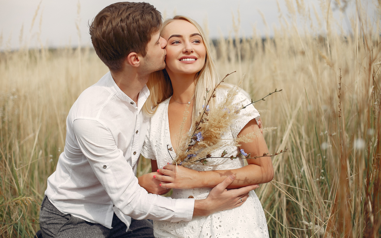 Поцелуй красивой пары на поле