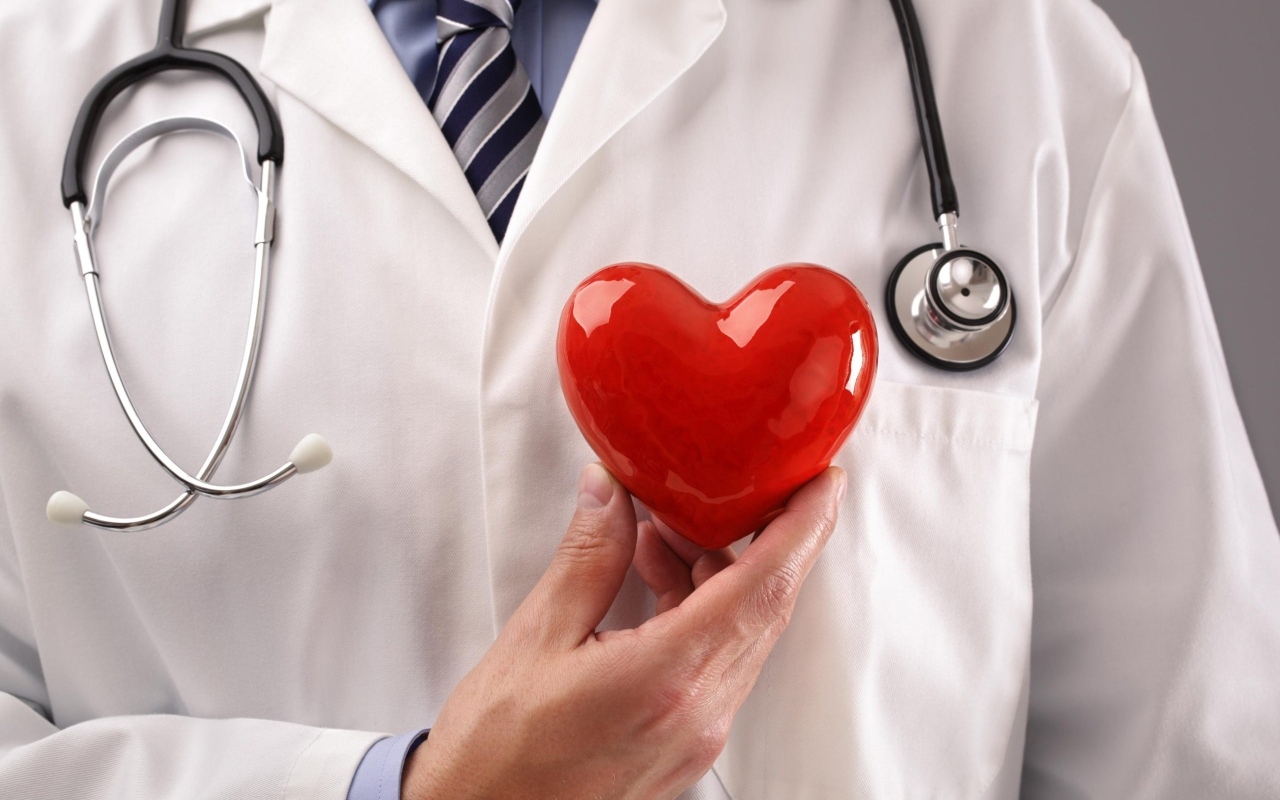 Красное сердце в руках доктора в белом халате