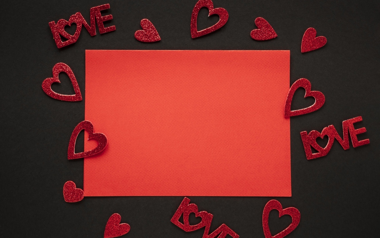 Красный лист бумаги на черном фоне с сердечками, шаблон для открытки