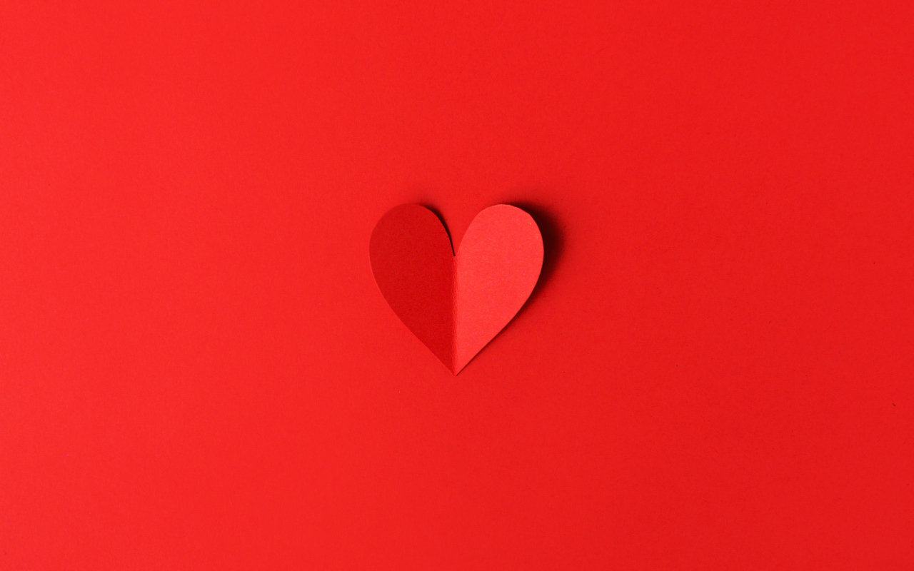 Маленькое бумажное сердце на красном фоне