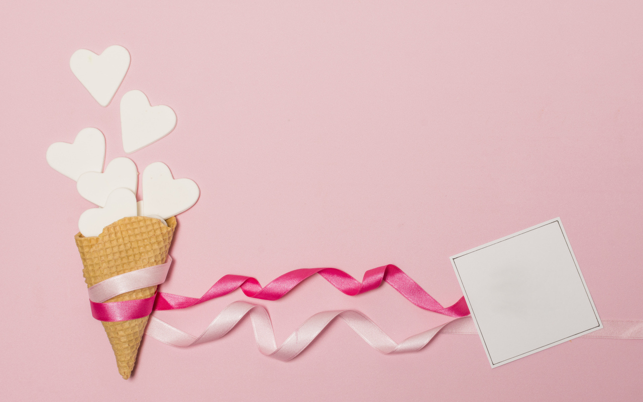 Вафельный рожок с сердечками, лентами и листом бумаги на розовом фоне