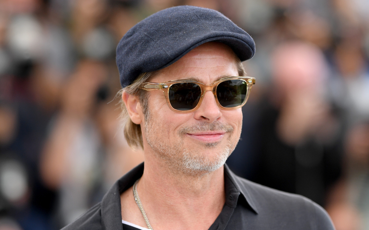 Актер Брэд Питт в кепке и очках