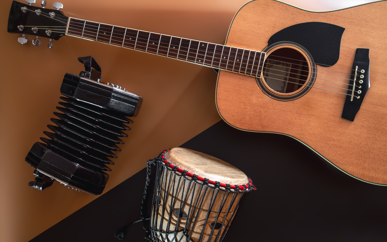 Гитара, гармошка и барабан на столе