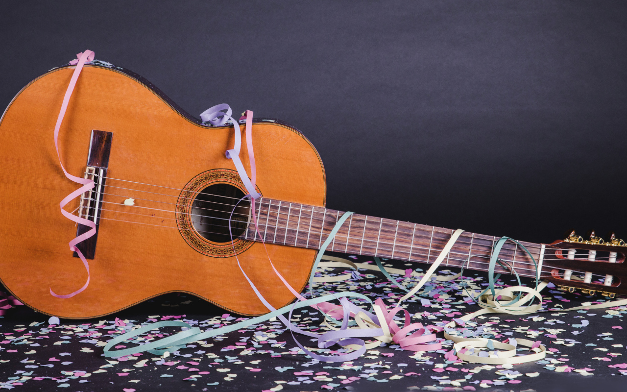 Гитара в конфетти у серой стены