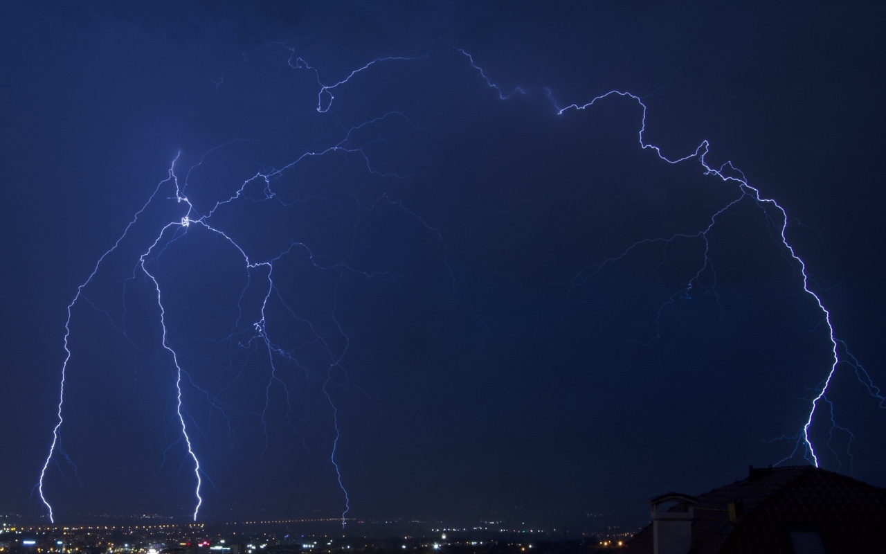 Белая яркая молния в небе над городом