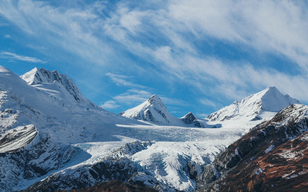 Высокие заснеженные горы под голубым ясным небом