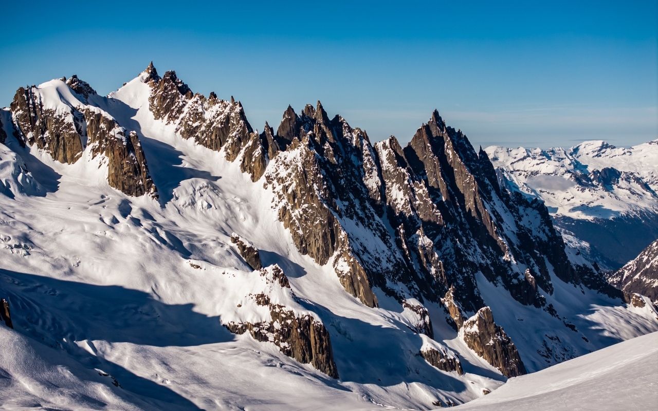 Солнце покрывает заснеженные горы