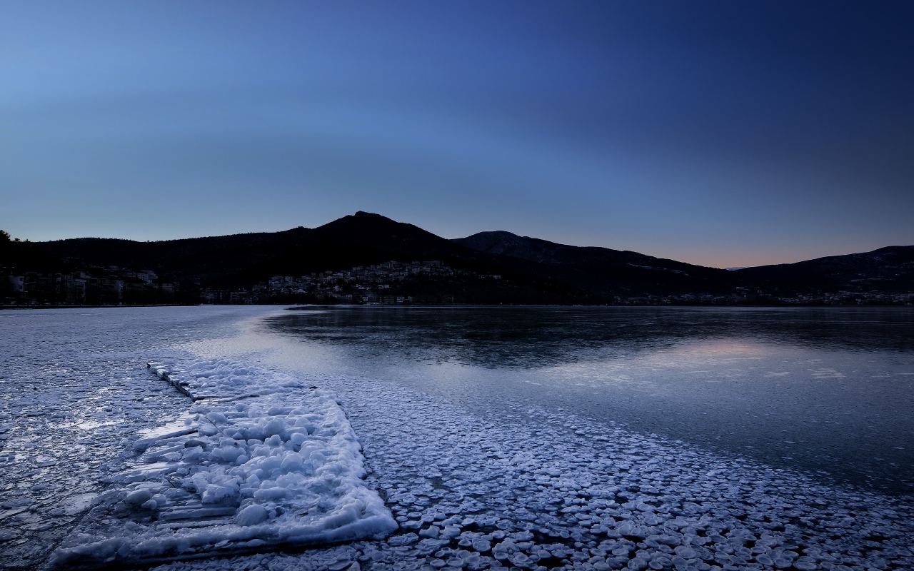 Заледеневшая вода в горном озере в сумерках