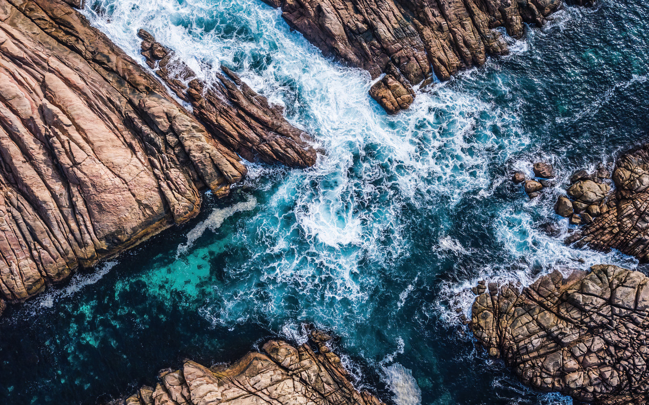 Вид на бушующее голубое море между камней 