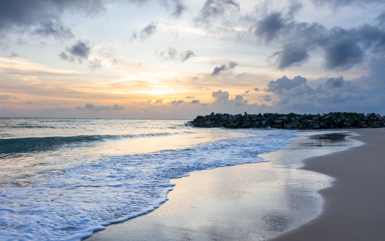 Волны омывают морской песок на рассвете