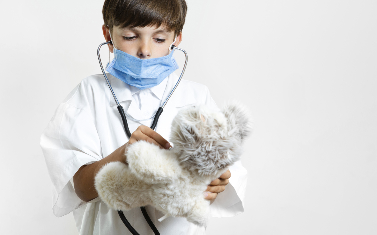 Мальчик в костюме врача с игрушечным медведем