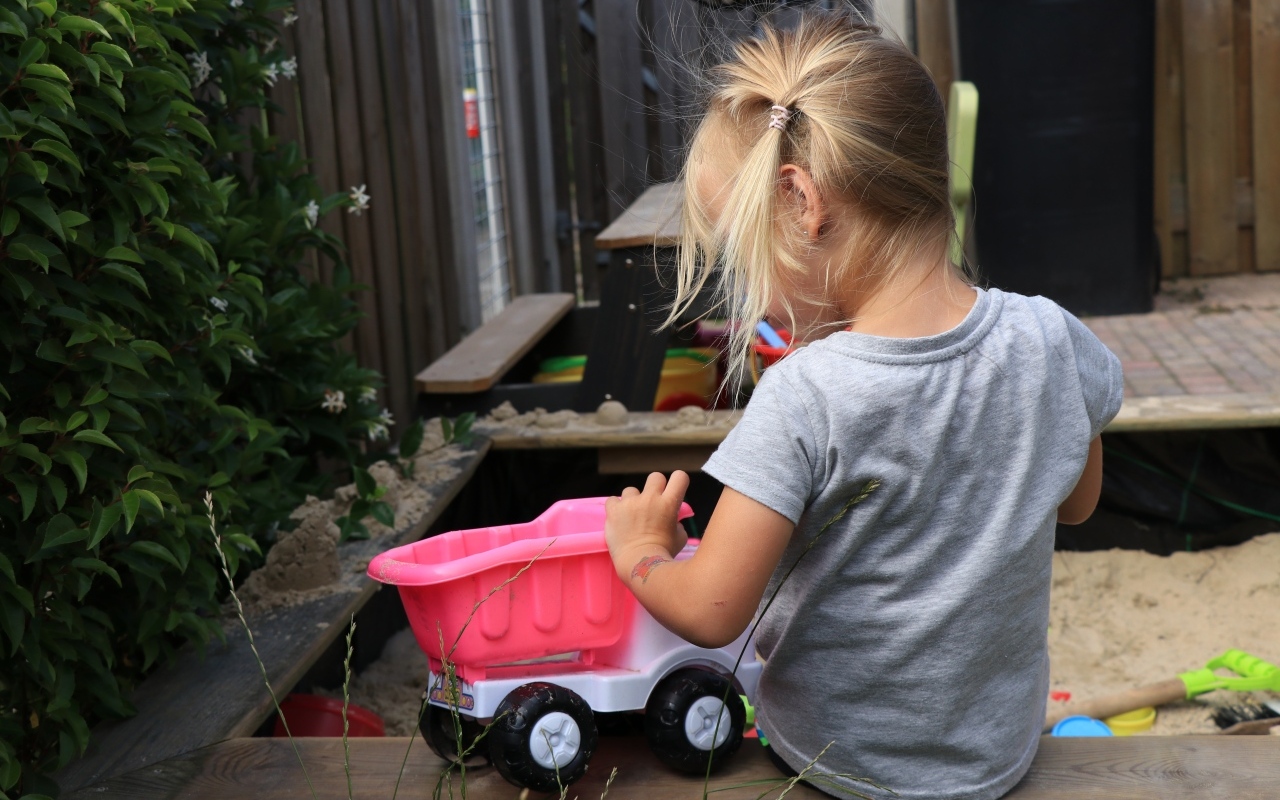 Девочка играет с игрушечной машинкой