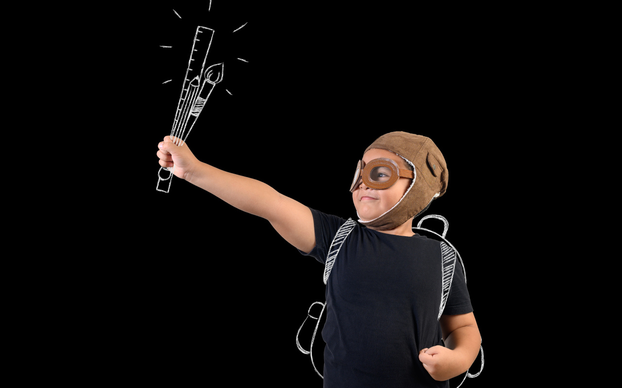 Маленький мальчик с нарисованными кистями на черном фоне