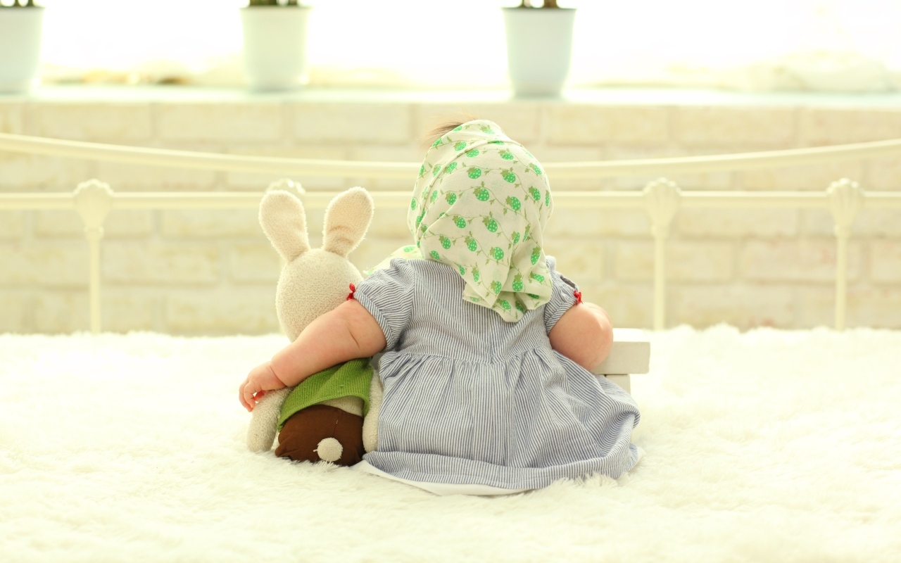 Маленькая девочка обнимает игрушечного зайца