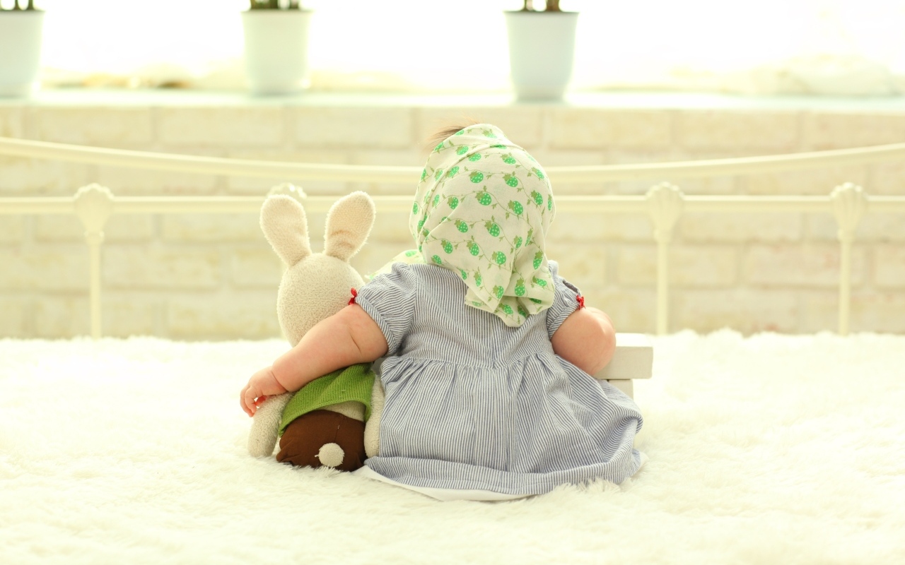 Маленькая девочка сидит с игрушкой