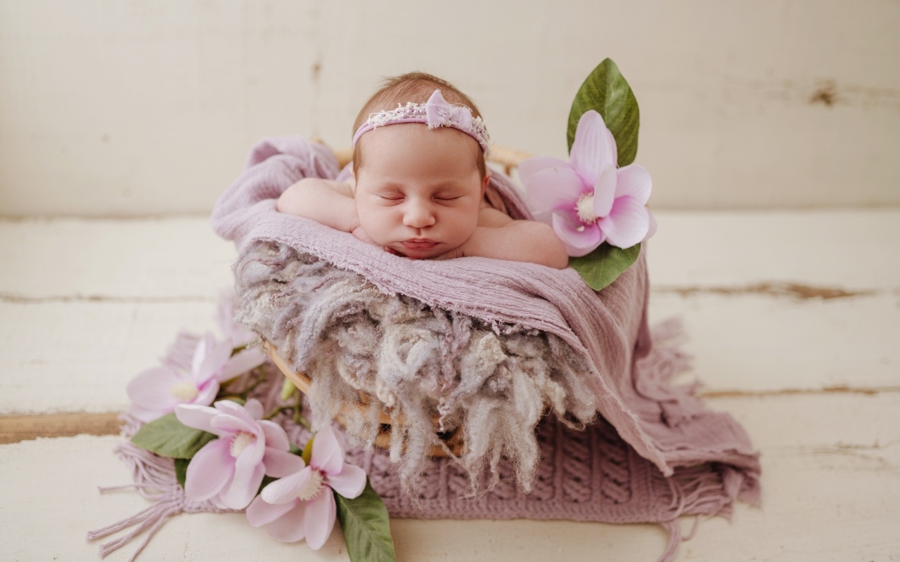 Спящая новорожденная малышка с цветами