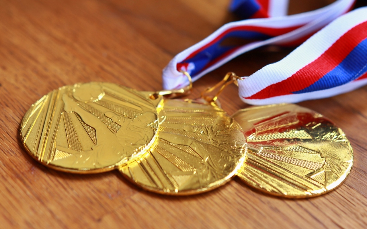 Три золотые медали на столе