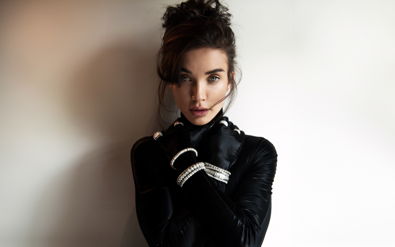 Актриса Эми Джексон стоит у стены