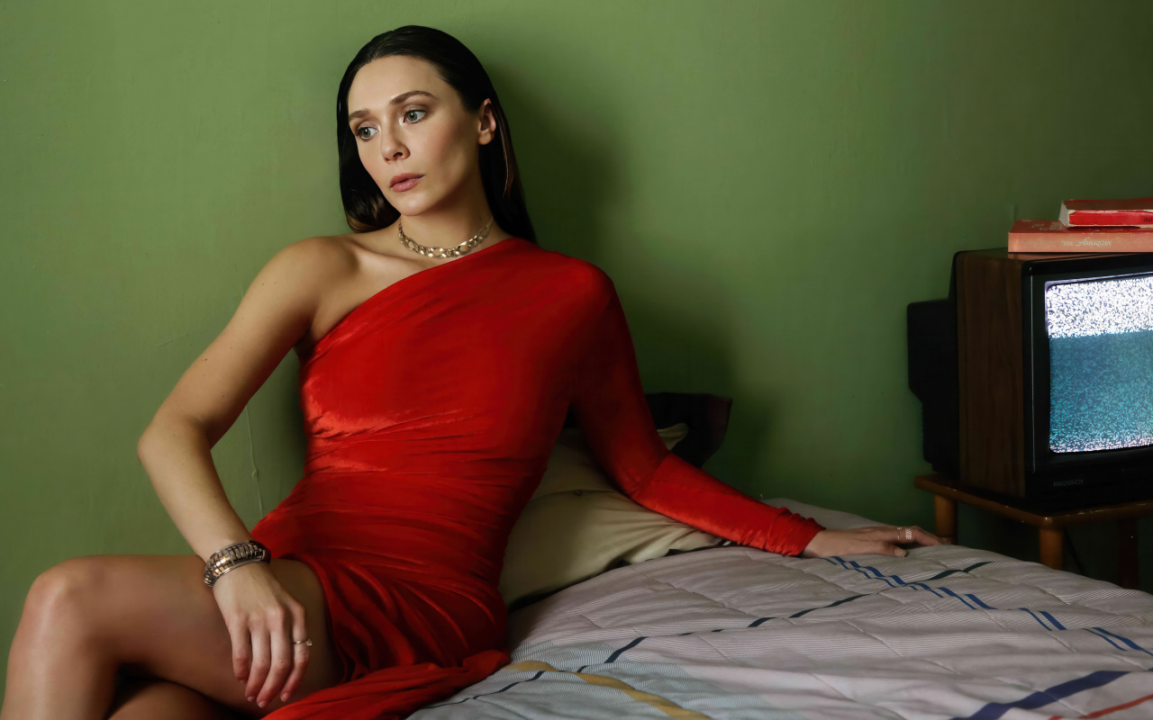 Актриса Элизабет Олсен в красном платье сидит на кровати