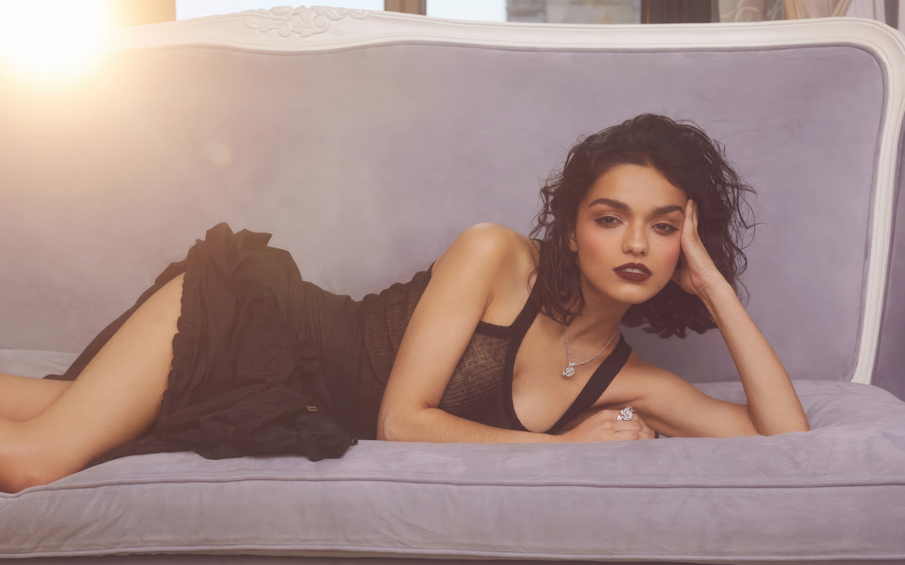 Актриса Рэйчел Зеглер в черном платье лежит на диване