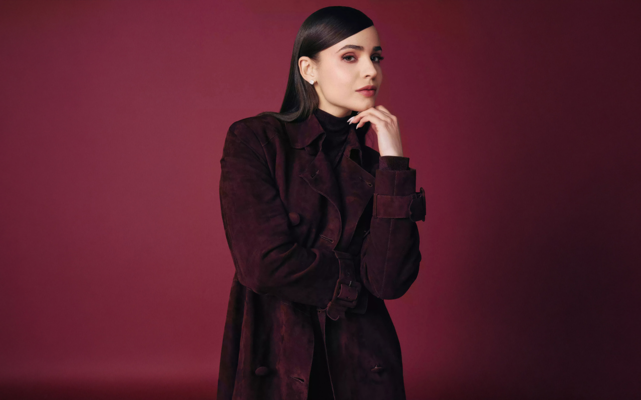 Актриса София Карсон в пальто на бордовом фоне