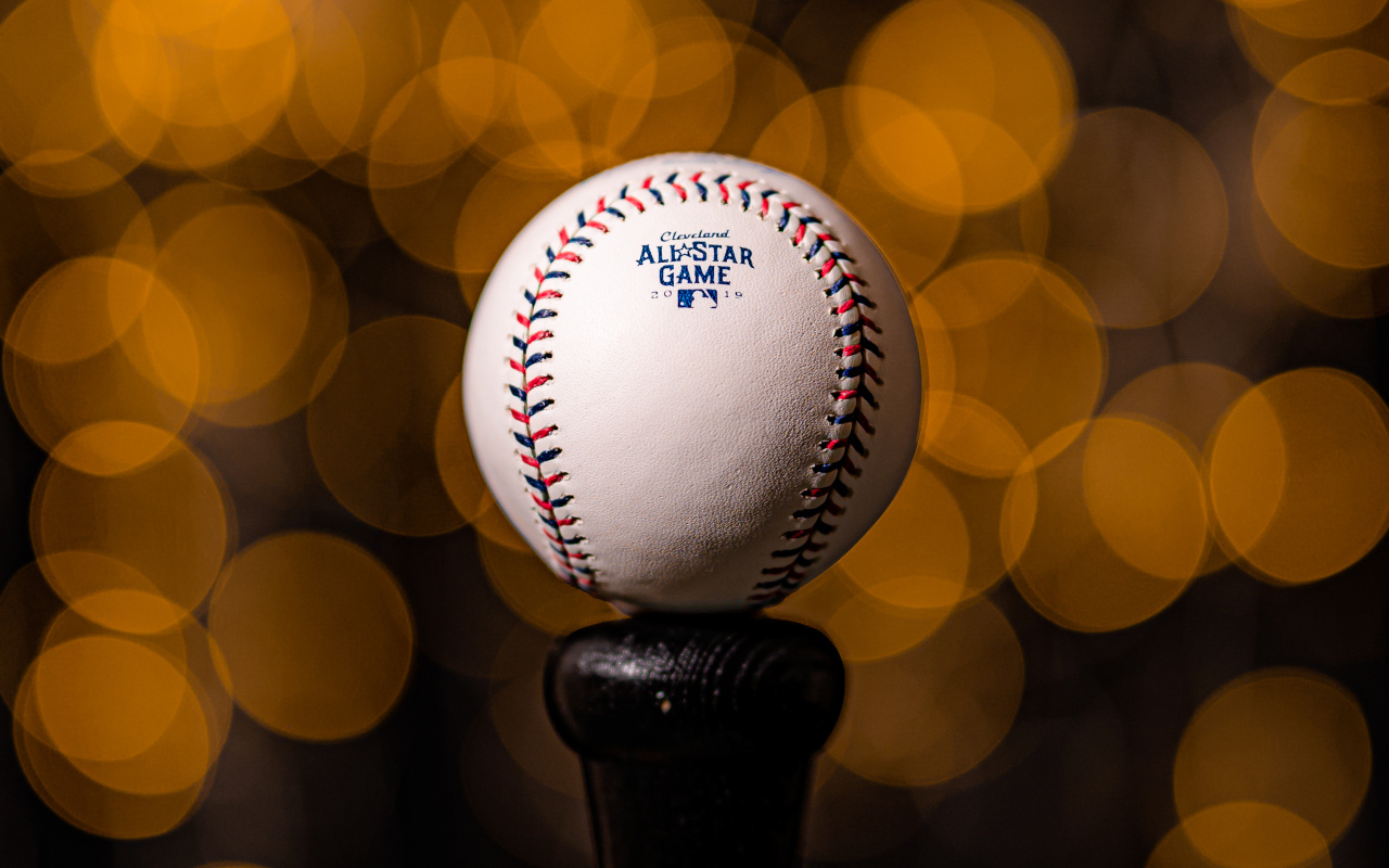 Бейсбольный мяч с битой на фоне бликов