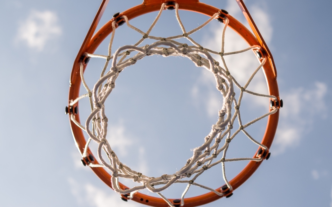 Вид снизу на баскетбольное кольцо на фоне неба