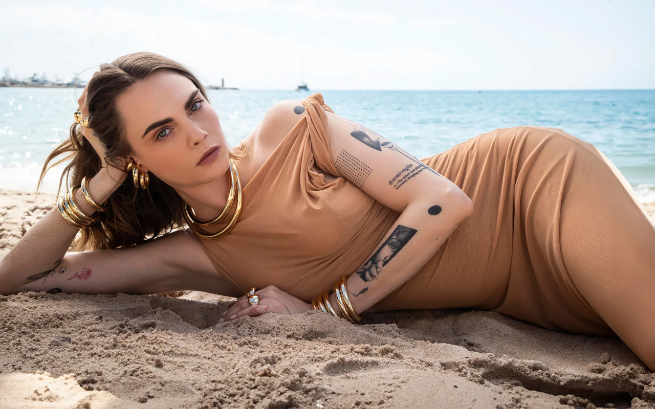 Британская актриса Кара Делевинь лежит на песке на пляже