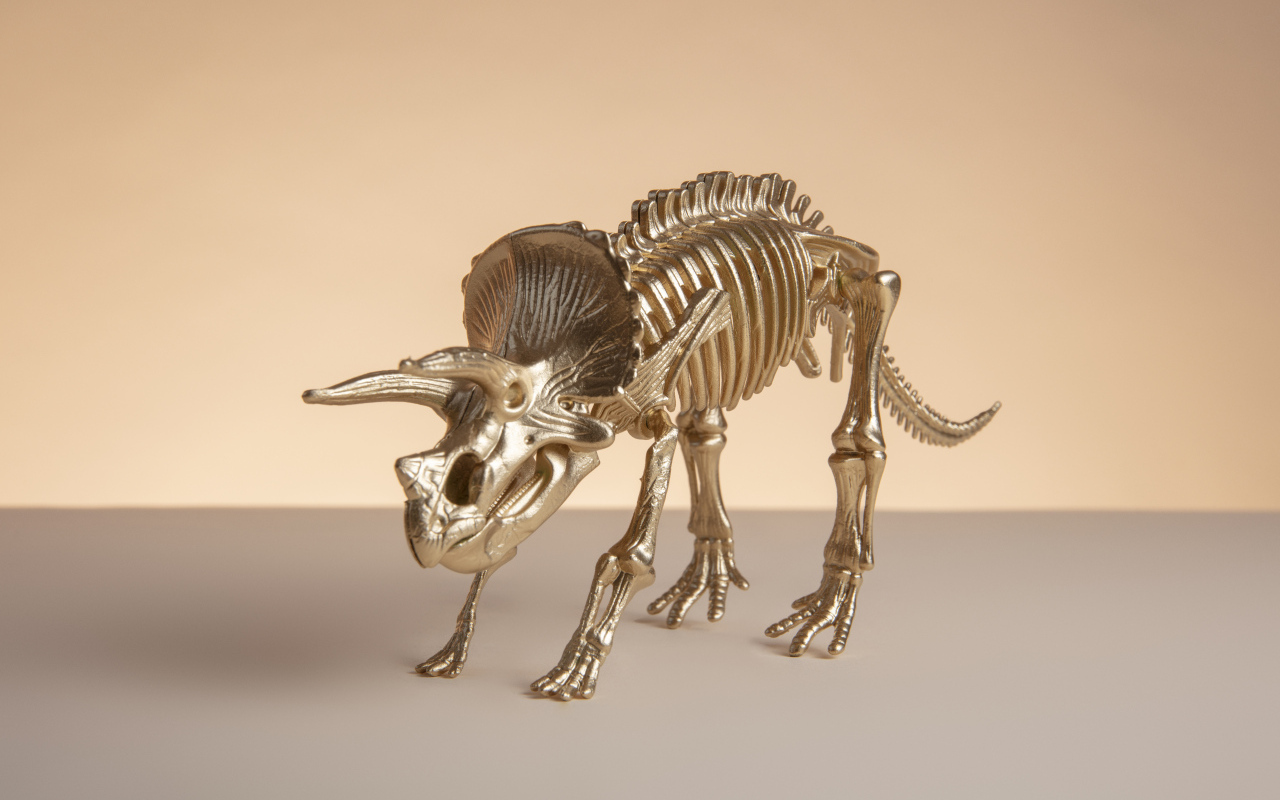 Золотой скелет динозавра на коричневом фоне