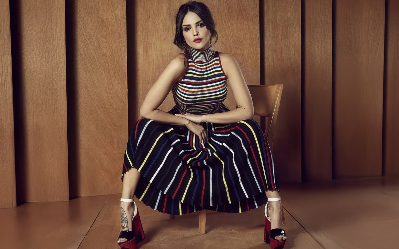 Мексиканская актриса Эйса Гонсалес в юбке сидит на стуле