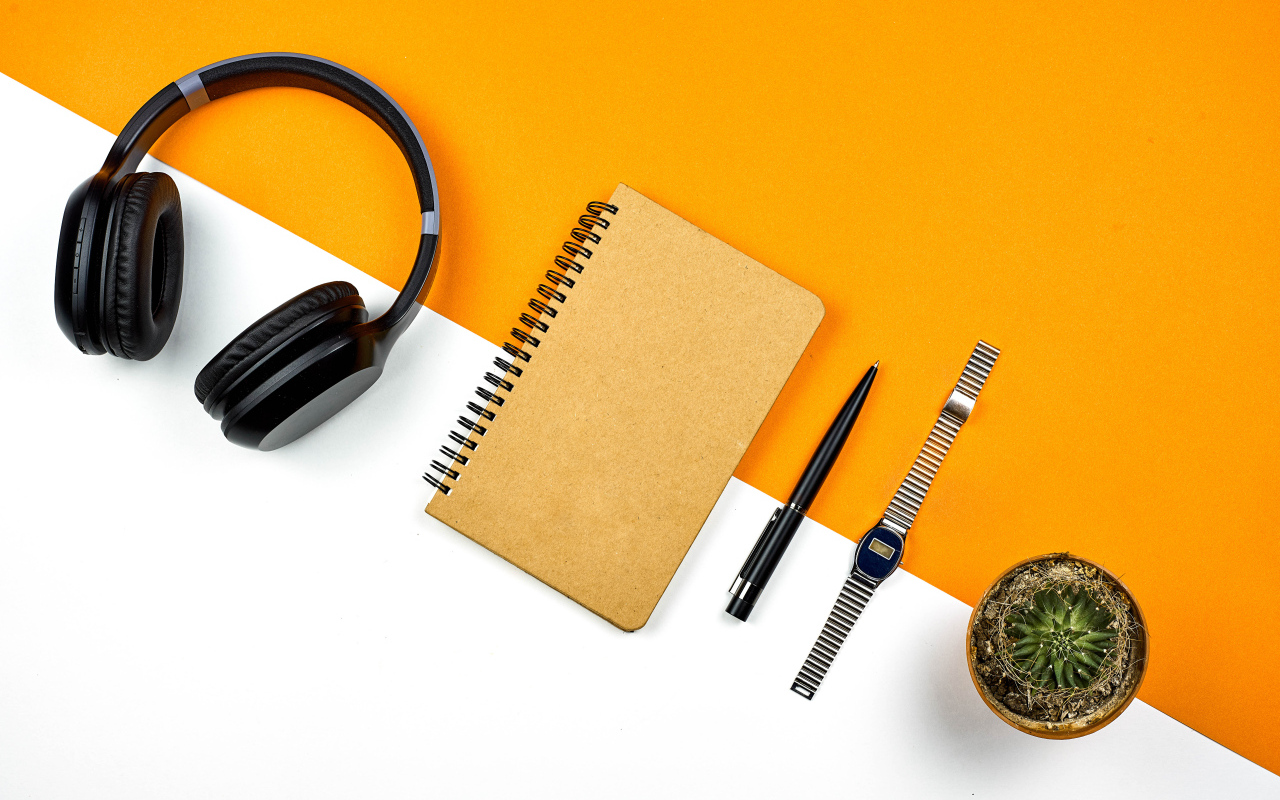 Наушники, блокнот, ручка, часы и цветок на фоне