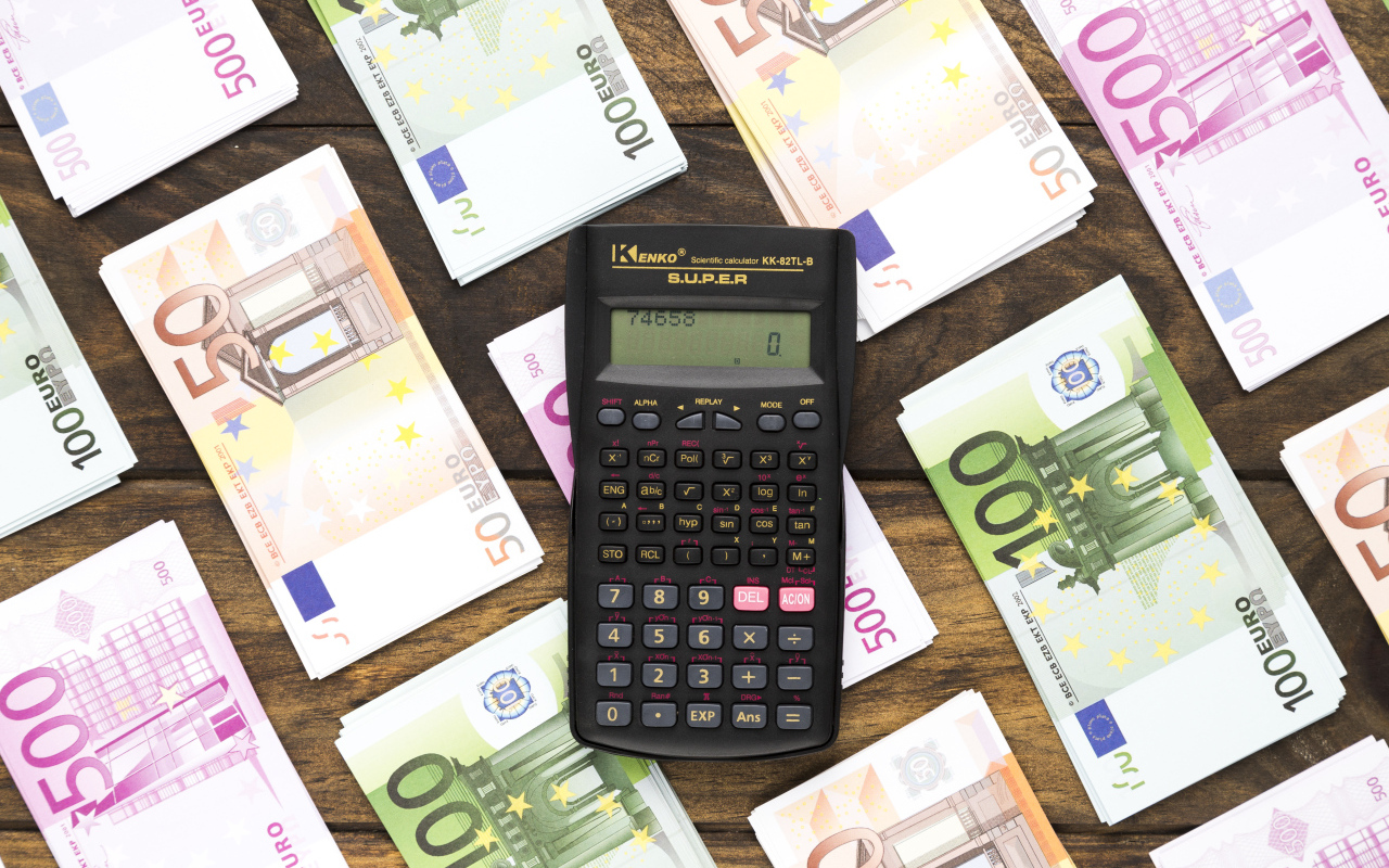 Калькулятор и купюры евро на деревянном столе