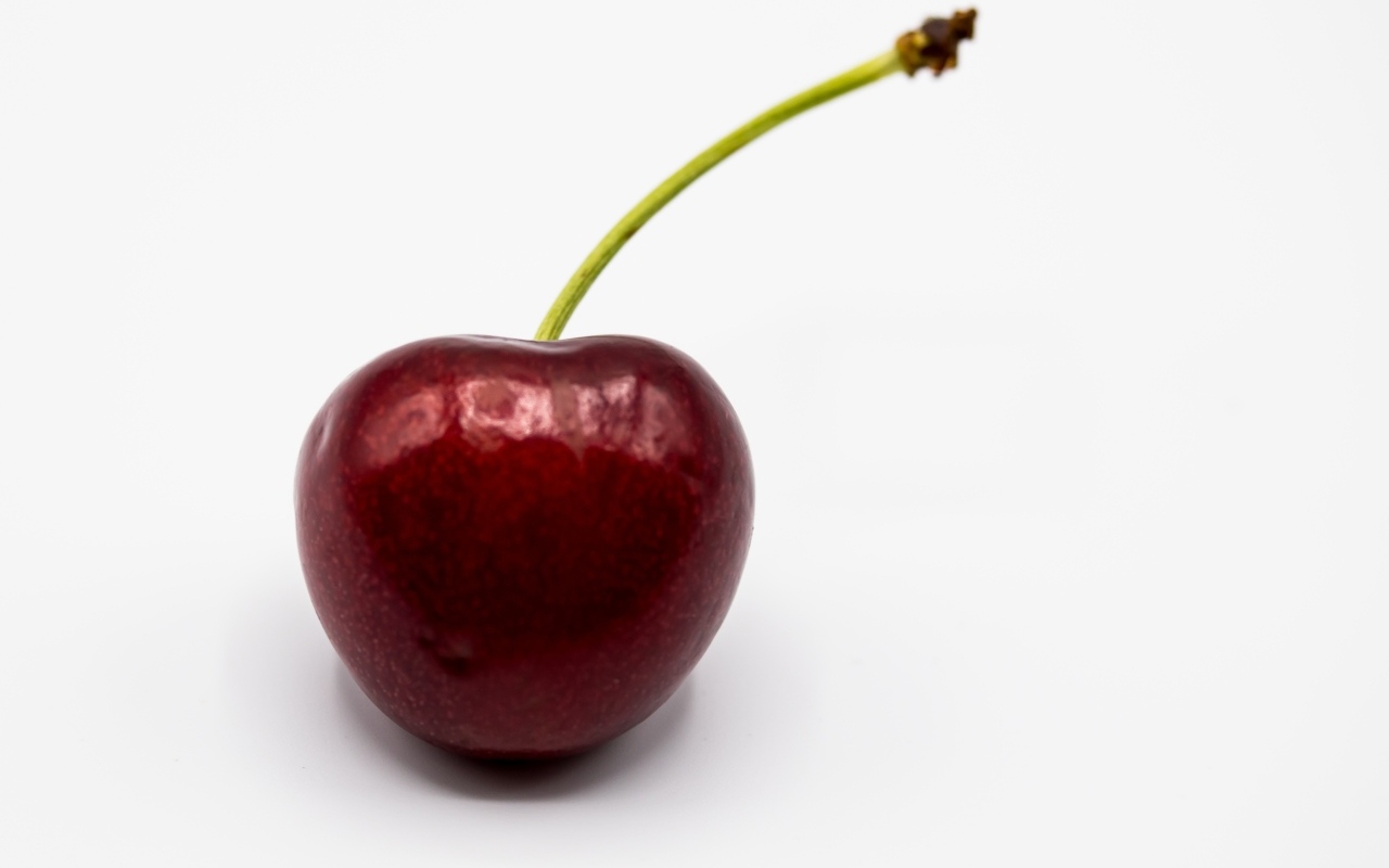 Крупная красная черешня на белом фоне