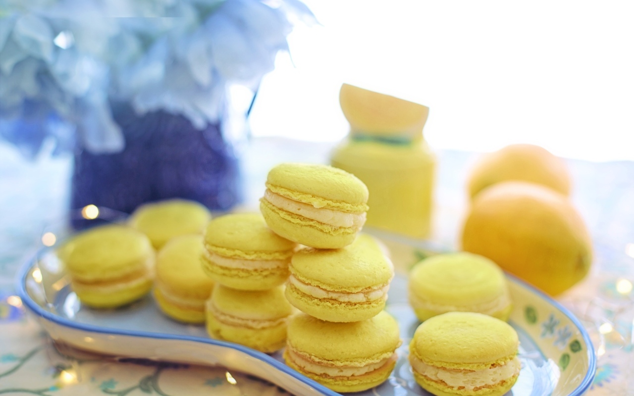 Десерт макарунс желтого цвета на тарелке на столе