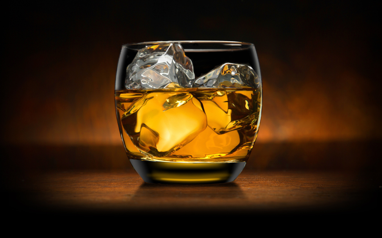 Стакан виски со льдом на столе
