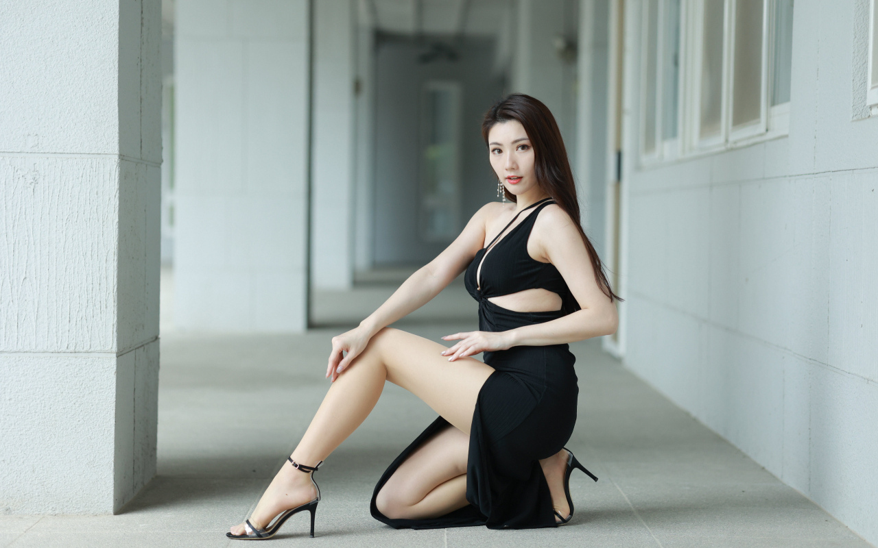 Девушка азиатка в черном наряде позирует для фото