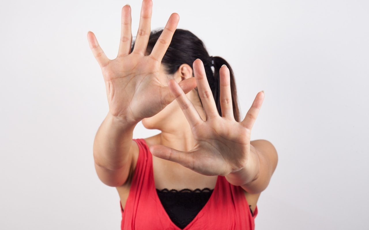 Девушка закрывает лицо руками