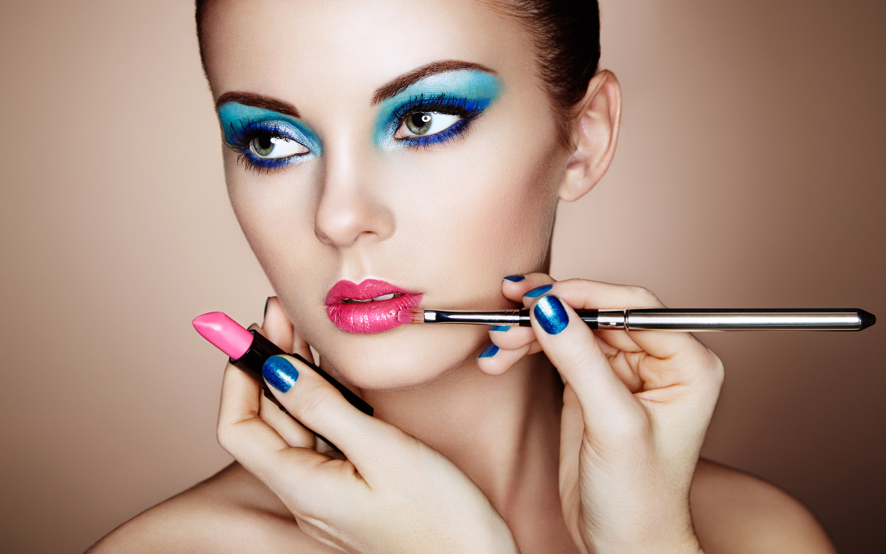 Девушке делают красивый яркий макияж