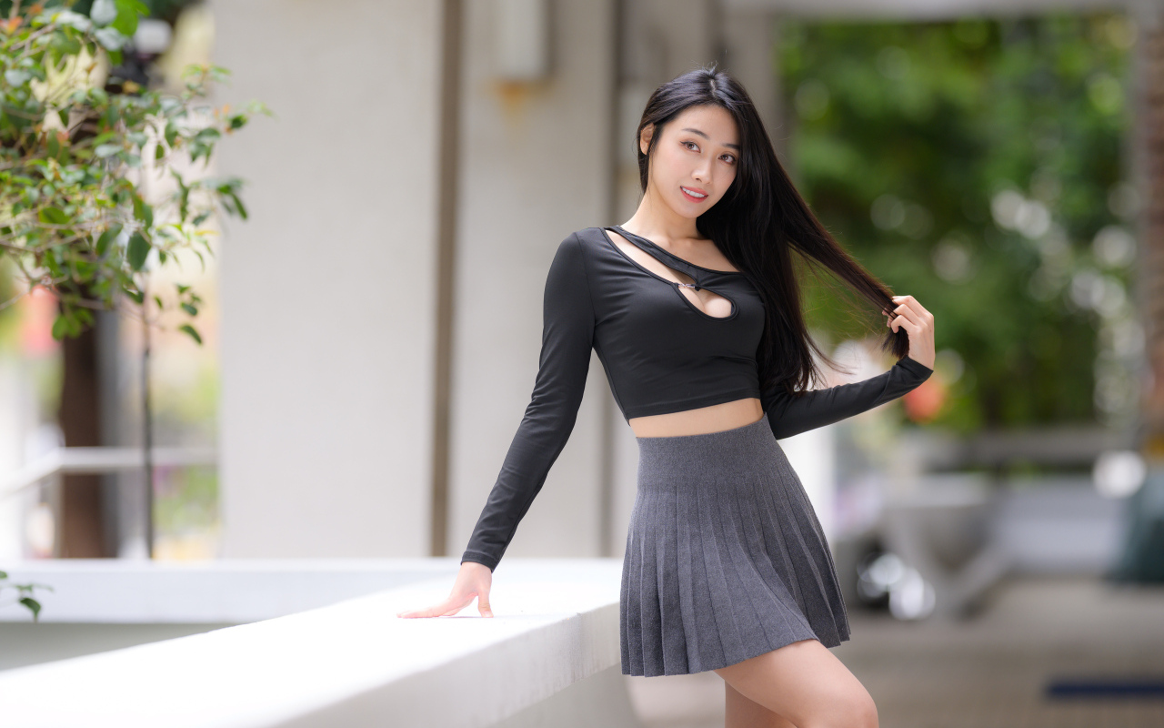 Молодая азиатка в короткой серой юбке