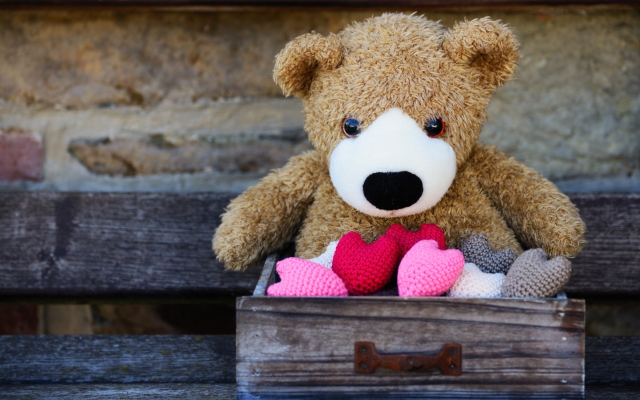 Игрушечный медвежонок с сердечками в деревянном ящике