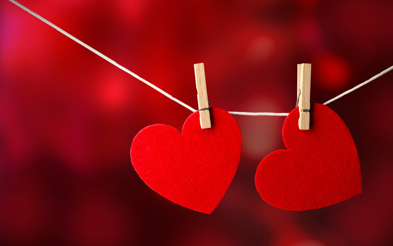 Два красных сердца висят на веревке