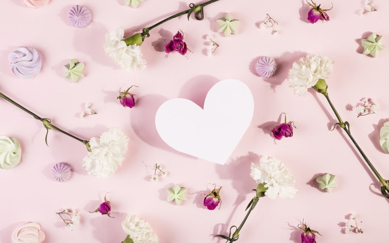 Белое бумажное сердце на розовом фоне с цветами